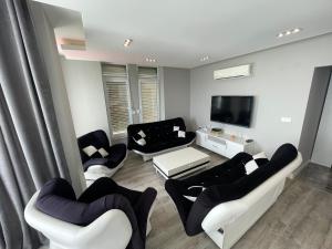 sala de estar con muebles en blanco y negro y TV de pantalla plana. en SA Apartments! Sea View 2bd Flat, en Alanya
