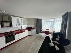 een keuken en een woonkamer met een bank en een tafel bij SA Apartments! Sea View 2bd Flat in Alanya