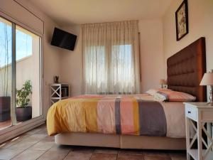 1 dormitorio con cama y ventana grande en Olivella Bed&breakfast, en Olivella