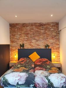 1 cama en un dormitorio con pared de ladrillo en Damietta en Haarlem