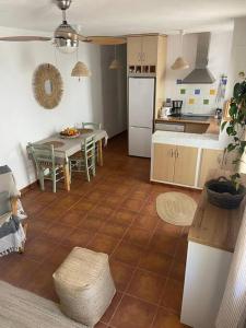 une cuisine avec une table et un réfrigérateur blanc dans l'établissement Casa Arlette, à Salobreña
