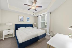 a bedroom with a blue bed and a ceiling fan at Sparks 1BR Water Views · Spring & Rooftop Patio in Sparks