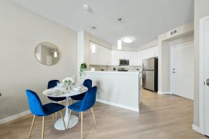 a kitchen and dining room with a table and blue chairs at Designer Apt with Jacuzzi, Sky Lounge, Gym Access in Sparks