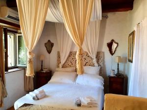 1 dormitorio con 1 cama blanca con cortinas en Bed and Breakfast Tenuta Palmieri en Cersuta di Maratea