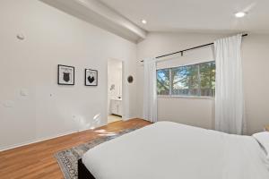 a white bedroom with a bed and a window at Delightful 4BR Home Nr Downtown Reno w Fireplace in Reno