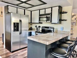 La cuisine est équipée d'un réfrigérateur et de placards en acier inoxydable. dans l'établissement DT Reno - 4BR Home with Patio, BBQ Grill, Games Room, à Reno