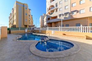 a swimming pool in the middle of a building at Apartament Glamour La Mata in Torrevieja