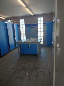 an empty bathroom with a sink and blue stalls at Bateau port Cap d'Agde in Cap d'Agde