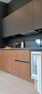 una cocina con armarios de madera y electrodomésticos de acero inoxidable en Casa Roman - nieuwe vakantiewoning - Deluxe 4p - Relax 4p - Comfort 4p -- ---Cosy 2p, en Zonhoven