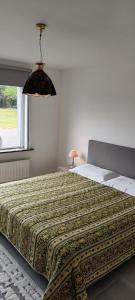 ein Schlafzimmer mit einem großen Bett mit einer Bettdecke in der Unterkunft Casa Roman - nieuwe vakantiewoning - Deluxe 4p - Relax 4p - Comfort 4p -- ---Cosy 2p in Zonhoven