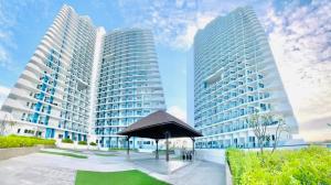 two tall buildings with an umbrella in front of them at Sonne & Strand AZURE NORTH PAMPANGA in San Fernando