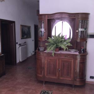 un gran armario de madera con una maceta en una habitación en Il Ciliegio, en Chiama