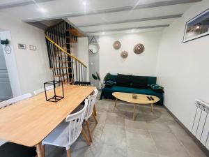 a living room with a green couch and a table at T3 COSY MAISON DE VILLE TERRASSE AU CALME in Rochefort