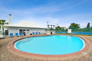 a large swimming pool with blue chairs around it at Beachside Villas by Panhandle Getaways in Seagrove Beach