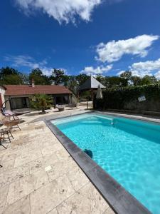 a swimming pool with blue water in a yard at Le Val de Nodicia in Montlivault