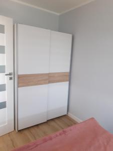 1 dormitorio con puertas blancas y alfombra rosa en Przytulny Apartament na Strzeleckiej en Płock