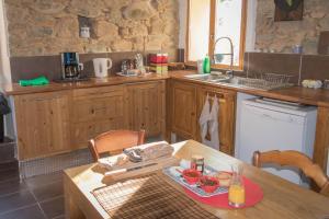 una cocina con armarios de madera y una mesa con comida. en a Casa, en Calenzana