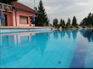 a swimming pool with blue water in front of a building at Stevin ranc in Bosanska Dubica