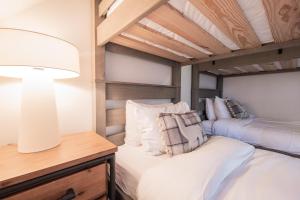 a bedroom with two twin beds and a lamp at Lake Placid Lodge by Outpost Whistler in Whistler