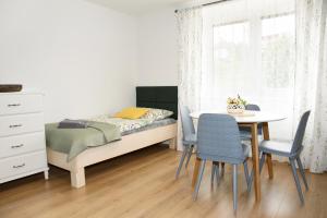 um pequeno quarto com uma cama, uma mesa e cadeiras em Apartmán Mločí údolí • Podyjí em Znojmo