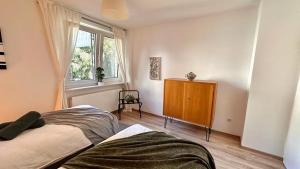 - une chambre avec un lit, une fenêtre et une commode dans l'établissement Business Suites-Fair-Balcony's-Uniklinik - for 8, à Essen