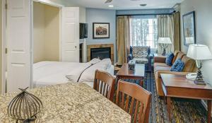 um quarto de hotel com uma cama e uma sala de estar em WorldMark Pinetop em Pinetop-Lakeside
