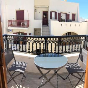 d'une table et de deux chaises sur un balcon. dans l'établissement Naxian Vibes Apartments, à Naxos Chora