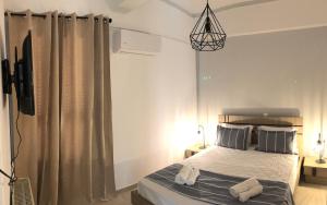 - une chambre avec un lit et une télévision dans l'établissement Naxian Vibes Apartments, à Naxos Chora