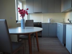 eine Küche mit einem Tisch und einer Blumenvase darauf in der Unterkunft B&K apartments in Panevėžys