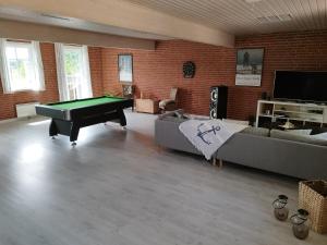 una sala de estar con una mesa de billar. en Ferielejlighed Rubjerg Præstegård, en Løkken