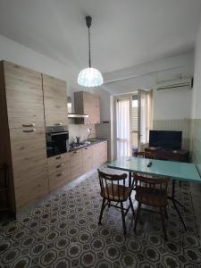 uma cozinha com uma mesa e duas cadeiras em Sant'Elena apartment Self check-in em Quartu SantʼElena