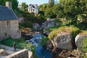 une personne debout sur un pont au-dessus d'une rivière dans l'établissement Blaz an Holen - Maison avec jardin à Guimaëc, à Saint-Jean-du-Doigt