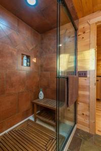uma casa de banho com um chuveiro com um banco em Fully Stocked Cabin Retreat w/ Game Room & Pond! em Marion