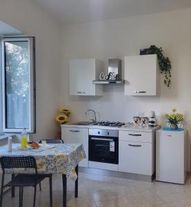 een keuken met witte apparaten en een tafel met een tafelkleed bij Casa Athena in Sorrento