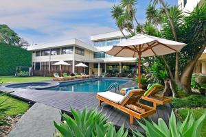 um resort com uma piscina com cadeiras e um guarda-sol em Auténtico Hotel em San José