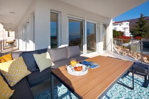 a living room with a couch and a table on a balcony at Villa Sunny Ičići- Apartment Sun in Ičići