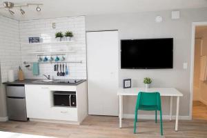 a kitchen with a table and a tv on a wall at Amazing Studio on Daytona Beach in Daytona Beach