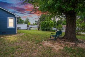 un banco verde sentado bajo un árbol junto a una casa en Comfy Home With Gated Garden I Family Reunion, en Oklahoma City