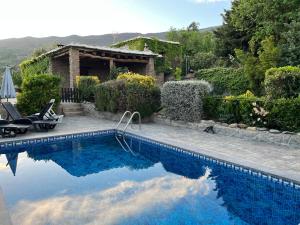 una piscina di fronte a una casa di Alpujarra Cortijo Casilla Noguera a Pórtugos