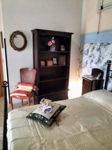 una camera con letto, sedia e cassettiera di La Villa del Conte a Scicli