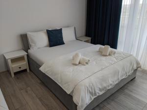a bedroom with a bed with two pillows on it at Alina's Deluxe Apartment and free private parking in Dumbrăviţa