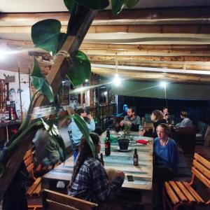 grupa ludzi siedzących przy stole w restauracji w obiekcie Casa Kayam Hostal y Residencia Artística w mieście Guatapé
