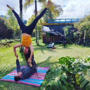 Ein Mann und eine Frau, die einen Handstand auf einer Decke machen. in der Unterkunft Casa Kayam Hostal y Residencia Artística in Guatapé