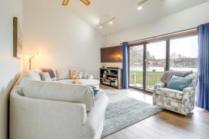 a living room with two couches and a large window at Cadillac Vacation Rental with Dock on Lake Mitchell! in Cadillac