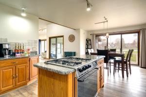 a kitchen with a stove and a dining room at Cadillac Vacation Rental on Lake Mitchell! in Cadillac