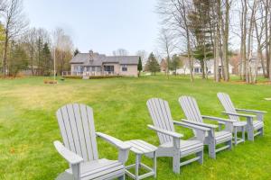 un grupo de sillas blancas sentadas en un patio en Cadillac Vacation Rental on Lake Mitchell! en Cadillac