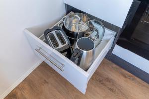 a white drawer with utensils in a kitchen at Daniels Apartment an der Schloßbrücke in Meißen