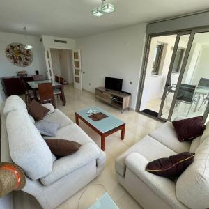 ein Wohnzimmer mit 2 weißen Sofas und einem Tisch in der Unterkunft Torredembarra in Torredembarra
