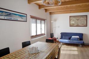 a living room with a table and a blue couch at Atirano in Tirano