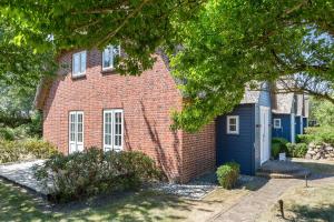 una casa de ladrillo rojo con garaje azul en Haus Moevengrund en List